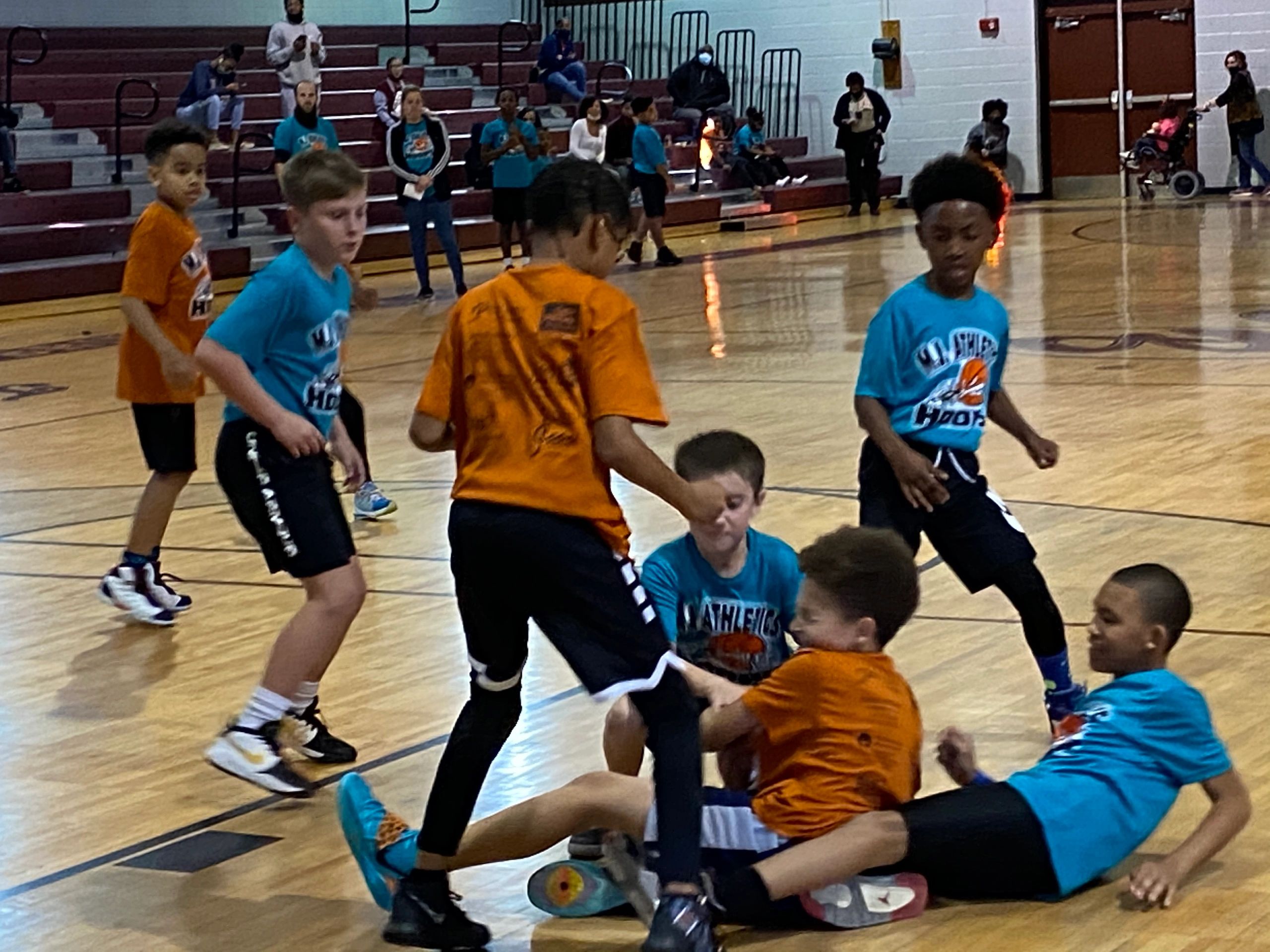 Youth basketball game with blue and orange uniforms