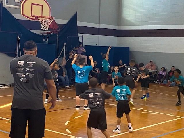 Coach instructing youth players on court